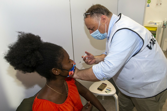 Viroloog Marc Van Ranst vaccineert een tienermeisje aan Park Spoor Noord