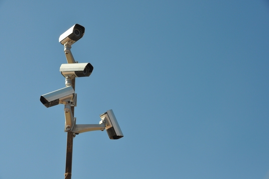 Een paal met verschillende bewakingscamera's op een achtergrond van een blauwe lucht.