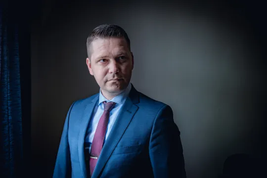 Europarlementslid Tom Vandendriessche (Vlaams Belang) kijkt met serieuze blik in de lens.