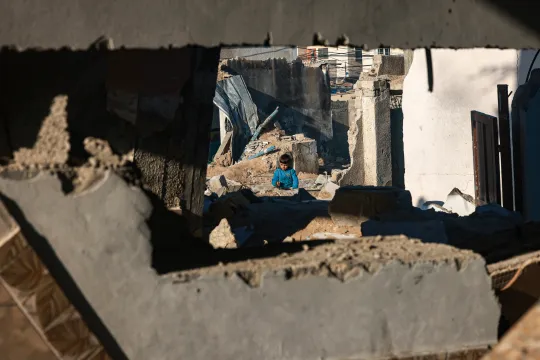 Een Palestijnse jongen speelt in het puin van de gebombardeerde stad Rafah in de Gazastrook.