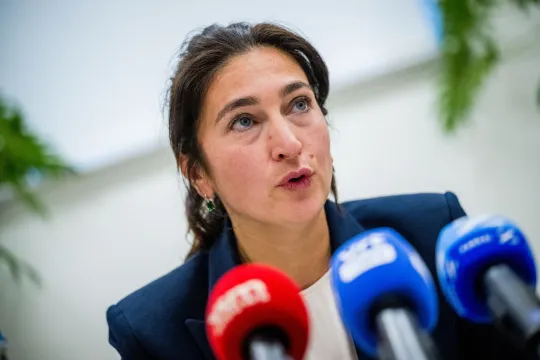Close-up van Vlaams omgevingsminister Zuhal Demir (N-VA), met voor zich enkele microfoons van media.