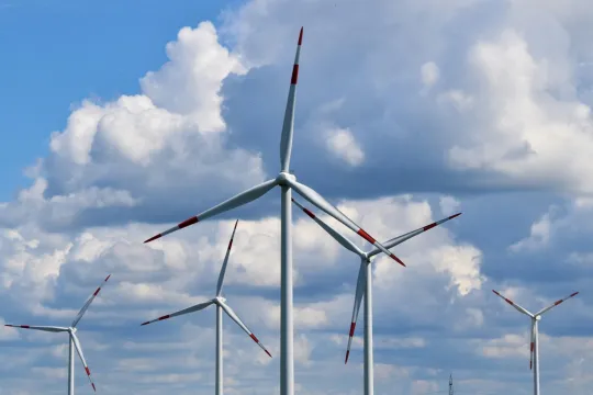 Een rij windmolens op een bewolkte achtergrond.