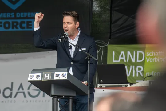 Tom Vandendriessche (Vlaams Belang) balt zijn vuist tijdens een speech op de landbouwprotesten van 4 juni 2024 in Brussel.