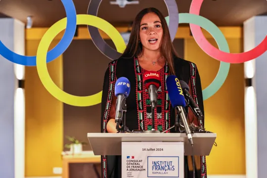 De Palestijns-Amerikaanse zwemmer Valerie Tarazi in een jurk versierd met traditioneel borduurwerk in de kleuren van Palestina.
