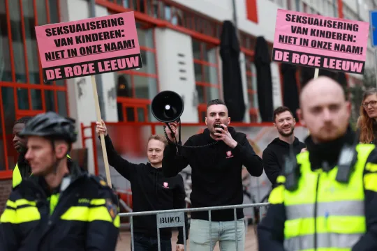 Met borden met daarop 'Seksualisering van onze kinderen: niet in onze naam' protesteren actievoerders van De Roze Leeuw in april 2023 tegen de voorleesmiddag Drag & Kids in Rotterdam.