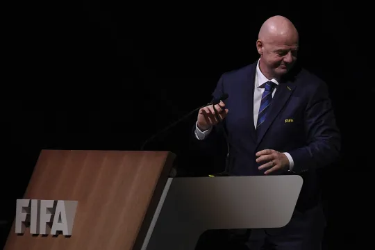 FIFA-voorzitter Gianni Infantino aan een spreekgestoelte met het logo van de wereldvoetbalbond na zijn herverkiezing tijdens een congres in Rwanda op 16 maart 2023.