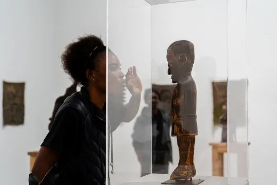 Het beeld van Maximilien Balot staat na een lange wereldreis in Eindhoven. Op de foto kijkt een vrouw naar het tentoongestelde beeld in het Van Abbemuseum