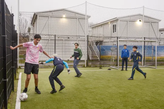 Kinderen spelen voetbal in het nooddorp voor Oekraïense vluchtelingen op Linkeroever.