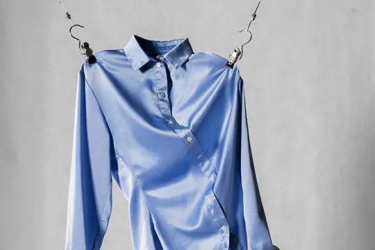 Een blauw hemd hangt aan de schouders aan twee kabels op.