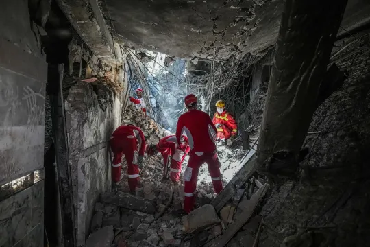 Iraanse reddingswerkers op zoek naar overlevenden in het puin na luchtaanvallen van Israël.