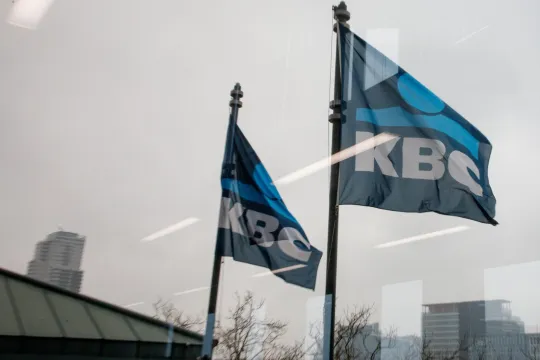 de vlag van KBC wappert voor een bankkantoor.