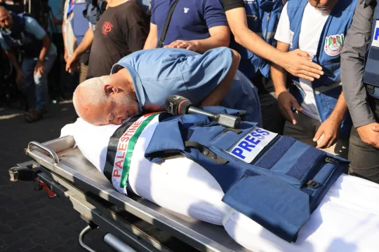 Een familielid neemt afscheid tijdens de begrafenis van journalist Mohamed Abu Hatab, de dag nadat hij werden gedood bij een Israëlische luchtaanval op zijn huis. 