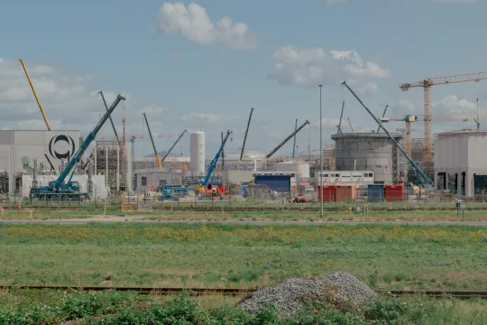 Bouwwerf van de Ineos-fabriek Project One, met meerdere stellingen en kranen.