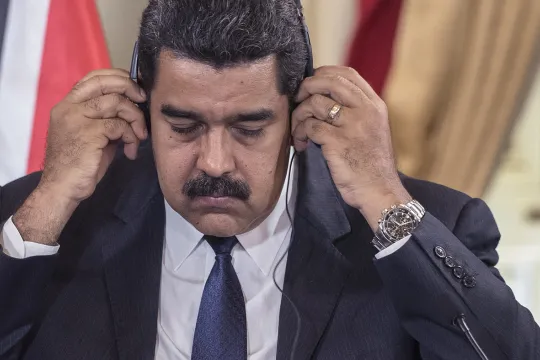 President Nicolás Maduro zet een hoofdtelefoon op. 
