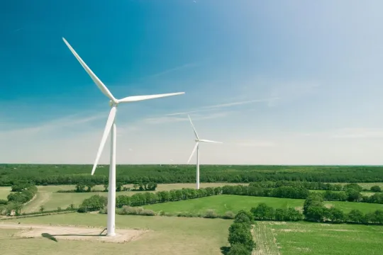 Windmolens op het platteland tegen een heldere blauwe lucht. 