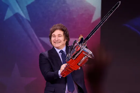 De Argentijnse president Javier Milei met een kettingzaag op een podium. 