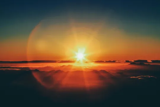 De zon verschijnt boven de wolken. 