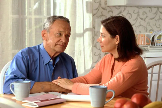 750px-Couple_sitting_at_a_kitchen_table_(1)