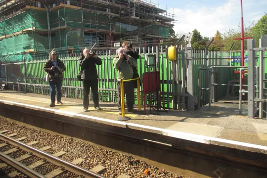 Vier personen op een treinperron met hun fototoestellen in de aanslag