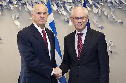 De Griekse premier Jorgos Papandreou schudt Europees president Herman Van Rompuy de hand (Foto