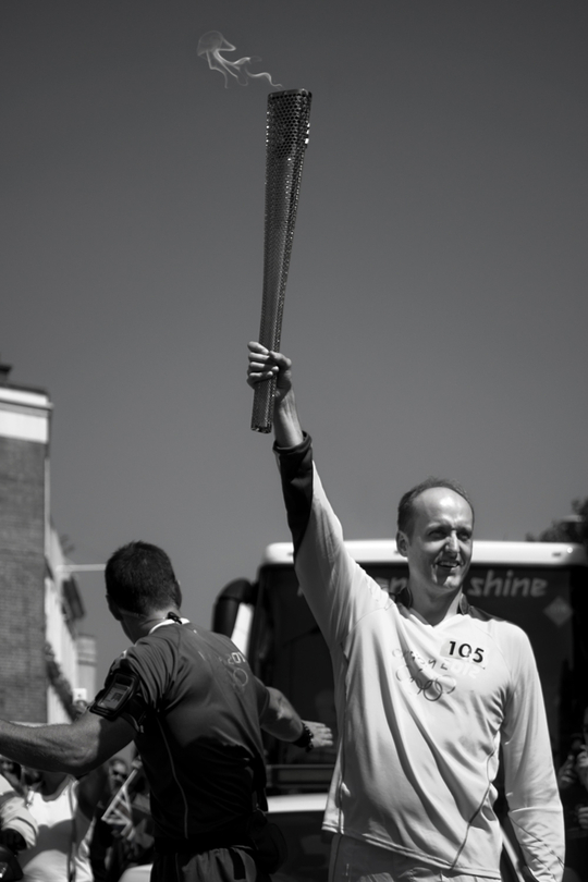 Chris Janzen uit Camden, Londen, draagt de Olympische fakkel (Foto Julia M. Free)