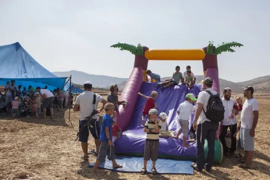 Op de plek waar vorige week een kolonisten echtpaar werd vermoord, op de Westelijke Jordaanoever, organiseerden kolonisten een kinderfeestje waarbij ze zichzelf beveiligden, met eigen wapens. Het Israelische leger sloot het gebied rondom hermetisch af. (Foto: Edmée van Rijn)