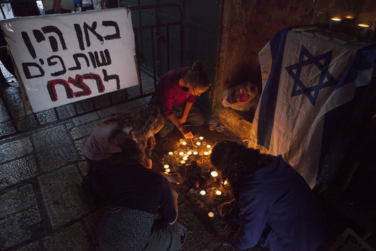 Een joods meisje maakt een Davidsster van waxinelichtjes op de plek in de oude stad van Jerusalem waar twee Israeli's werden doodgestoken. (Foto: Edmée van Rijn)