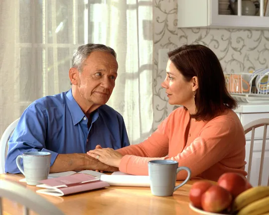750px-Couple_sitting_at_a_kitchen_table_(1)