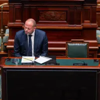 Theo Francken zit alleen aan een tafel in het parlement