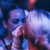 Een vrouw kijkt flirterig naar een andere vrouw