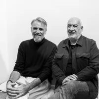 Zwartwitfoto van Sven Tuytens en Vincent Scheltiens die naast elkaar zitten. 